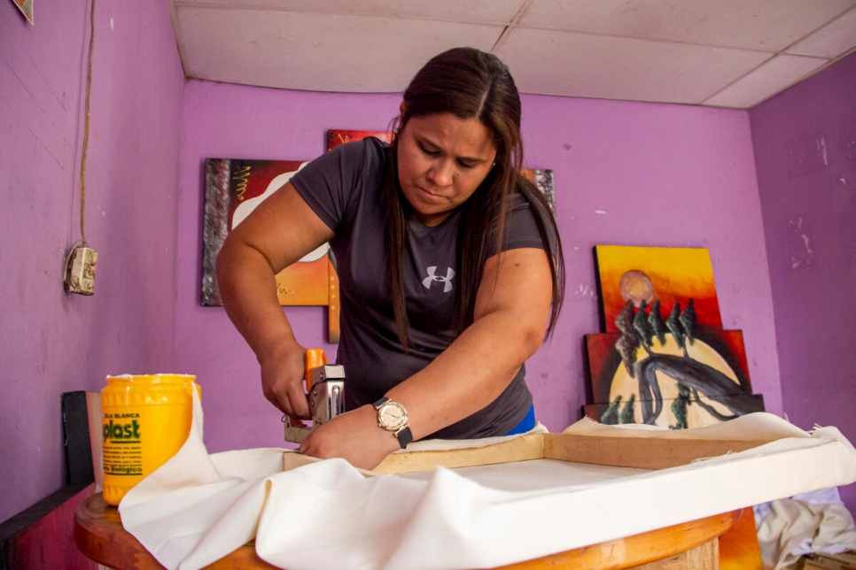 María José Mercado stretches one of the canvases that her husband will paint.
