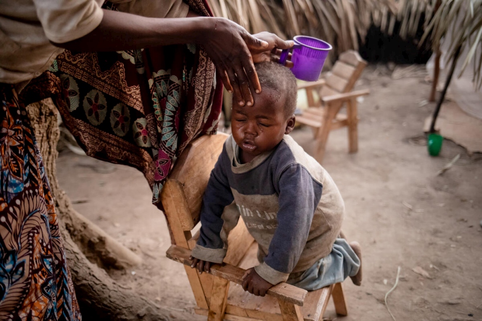 Pascaline gives her young son's face an early morning wash shortly after waking up.