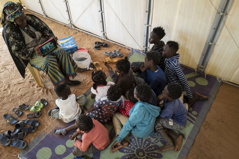 Refugee children watch a video to help them learn French at the Emergency Transit Mechanism in Hamdallaye, near the Nigerien capital Niamey. Language skills will be useful in finding durable solutions for them. 