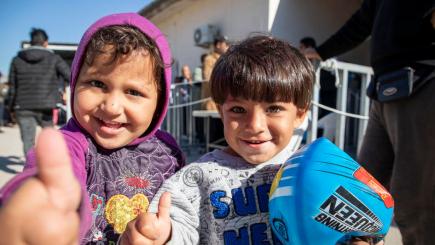 Two children in a refugee camp smiling