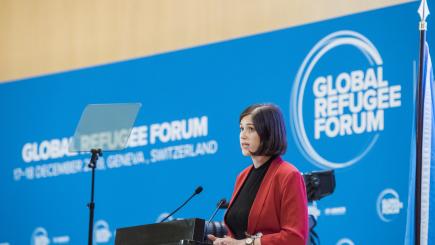 a woman speaks on a podium