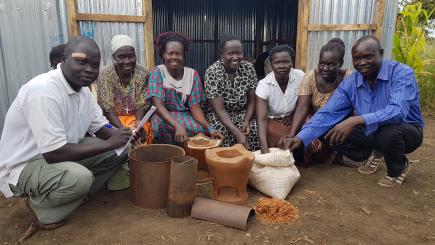 A group of people show a range of cooking pots