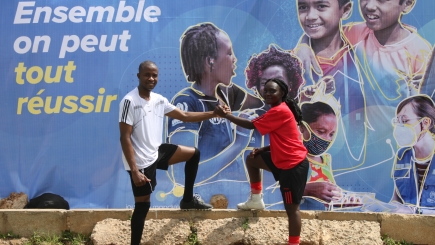 Two people wearing soccer jerseys shaking hands