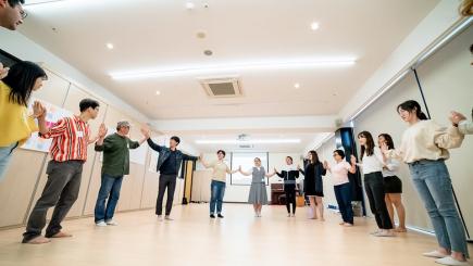 People touching hands in a circle in a room.