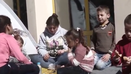 Children sitting on the ground.