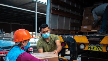 Man and woman unload cardboard crates from truck 