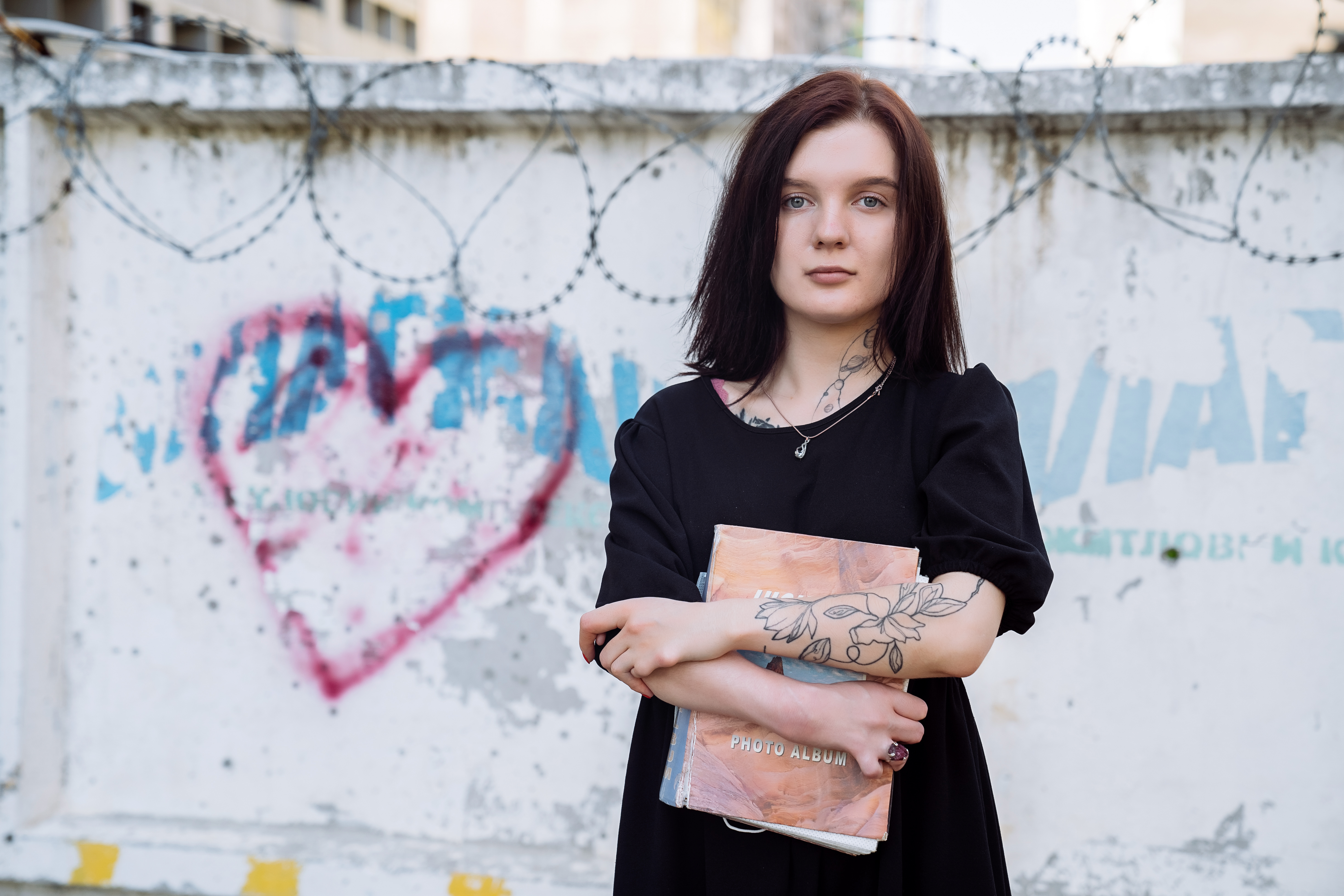 Woman holding a book and looking forward.