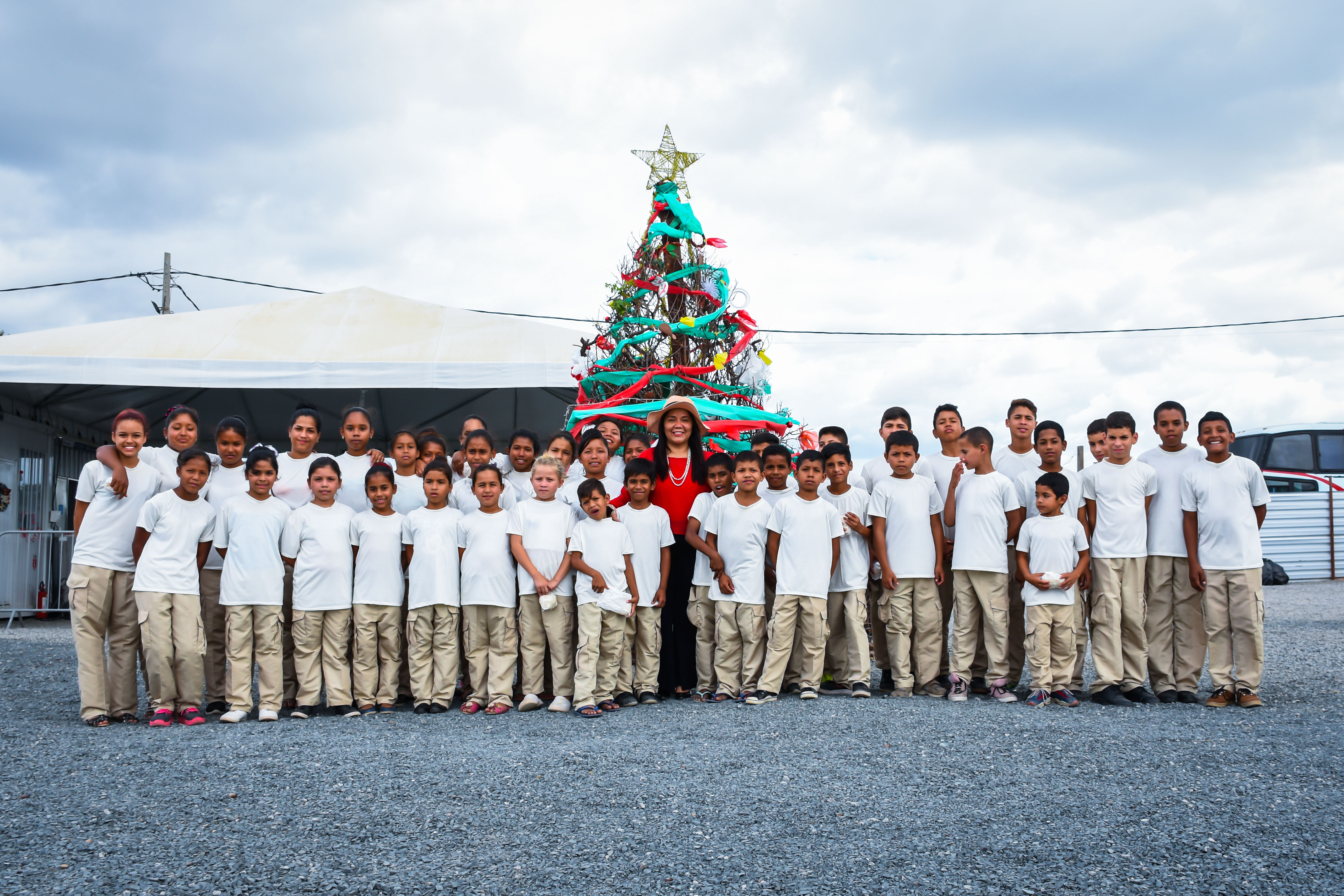 Children standing in front of a Christmas tree.