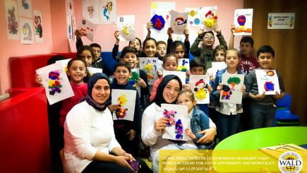 Woman and kids holding images facing the camera.