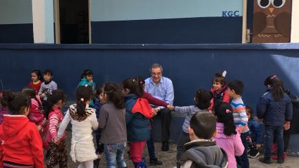 A group of children playing in a playground with a member of the ProFuturo Foundation team