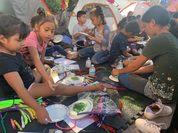 Children playing and drawing in the floor.