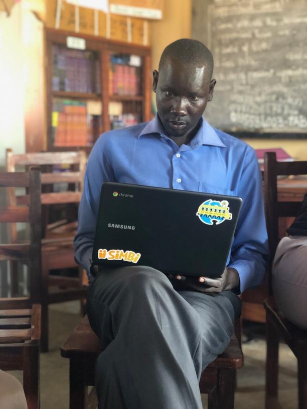 Man looking sitting on a chair looking at a laptop