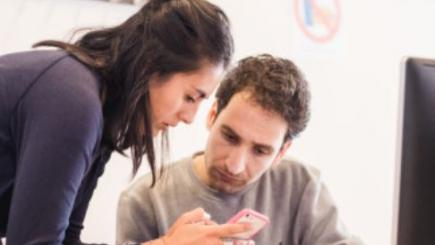 Woman and man looking at a tablet.