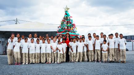 Children standing in front of a Christmas tree.