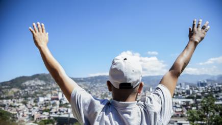 Honduras. A boy looks at a city view.