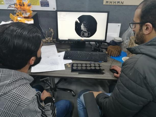 Two men working at a computer as part of the Clean Energy Challenge 