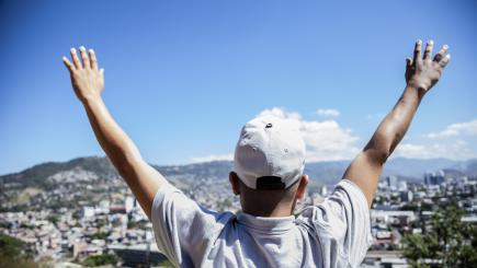 Man with arms outstretched towards the sky 