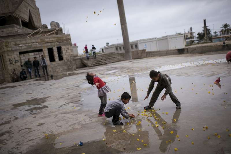 Lebanon/ Syrian refugees/ Saida: Syrian refugees play outside of the Ouzai collective shelter in Saida, Lebanon, March 4, 2014. Lebanon, a country of just over four million people, is preparing to officially register its one millionth Syrian refugee as the Syrian conflict reaches its third anniversary.  Fifty percent of the Syrian refugees are children, most of whom have been out of school for up to three years.  Lebanon's resources have been overburdened by the surge in population, and with no official refugee camps in the country, Syrians are forced to live in makeshift shelters across the country. UNHCR/Lynsey Addario/ March 2014
