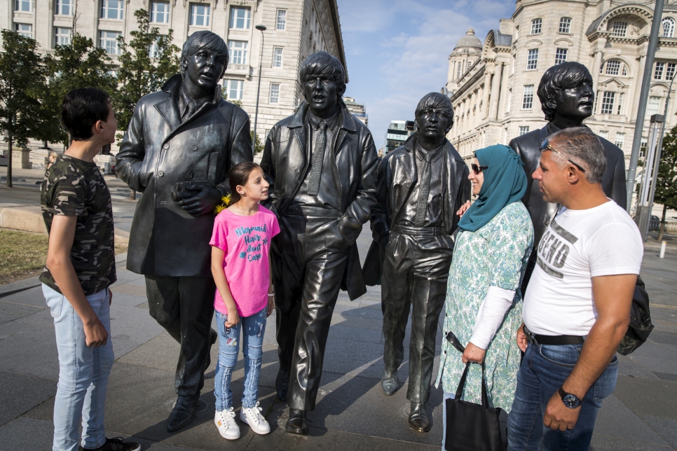 The Khaled Jhayem family (left to right) Adel, Ola, Ghofran and Ismael, stand near The Beatles statue on the waterfront in their new home, Liverpool. Ghofran had feared moving the children to a new country, and culture, but after six months she says they are happy.