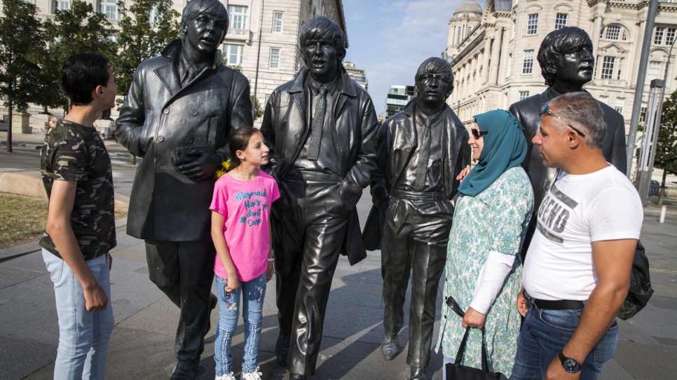 "The children have become happy. The welcome from people was great."

The Khaled Jhayem family (left to right) Adel, Ola, Ghofran and Ismael, stand near The Beatles statue on the waterfront in their new home, Liverpool. Ghofran had feared moving the children to a new country, and culture, but after six months she says they are happy.