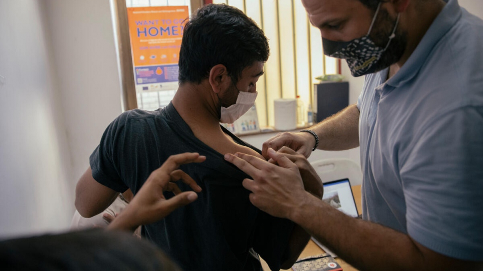 Nikola Kovačević looks at the injuries of an Afghan asylum-seeker who was pushed back from the border.