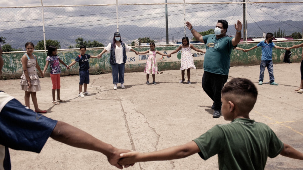 Edras Levi Suazo, who is in charge of communications at Jóvenes Contra la Violencia, organizes an activity with children in Nueva Capital, Honduras.