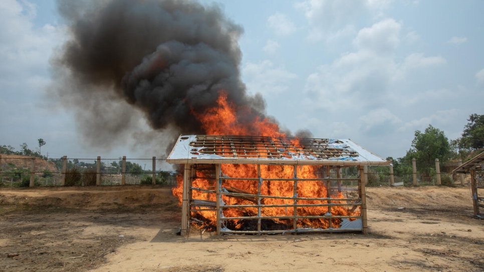 A shelter built for the purpose is burned as part of a training drill for refugee volunteers learning how to control fires. 