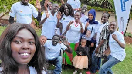 A group of people face the camera and smile.