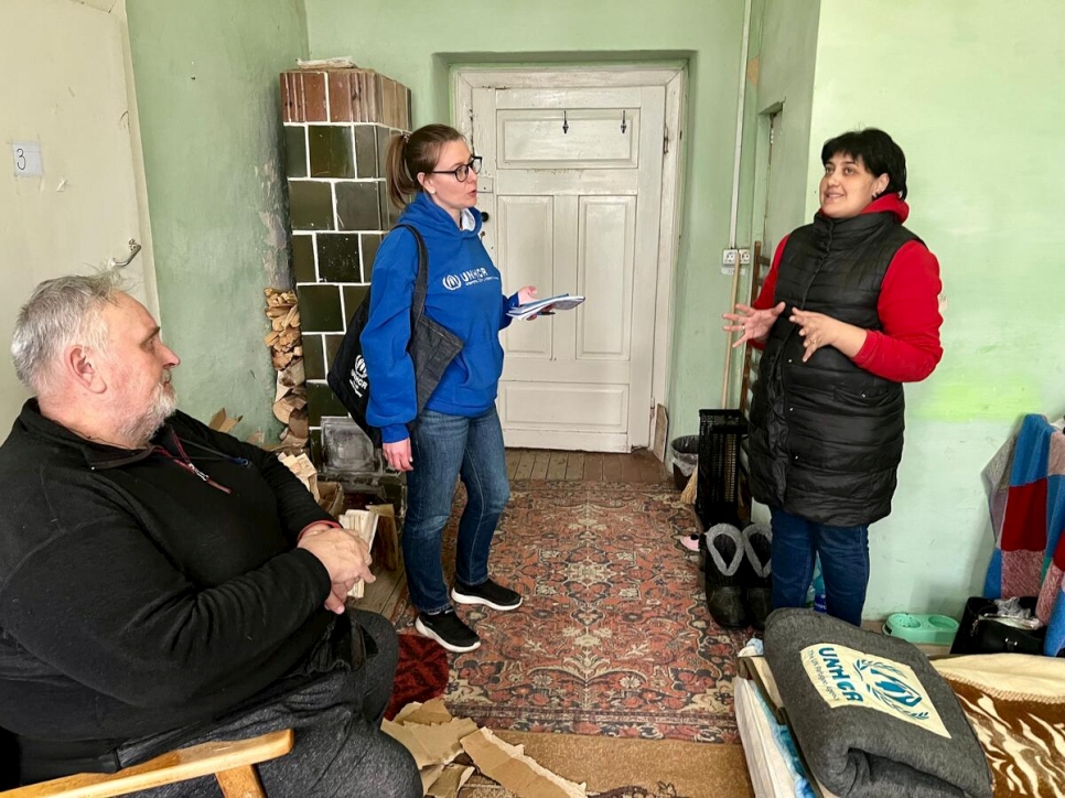 UNHCR Ukraine field officer Nadiia Vakhovska (centre) meets with Rymma and Viktor during a visit to the hostel.