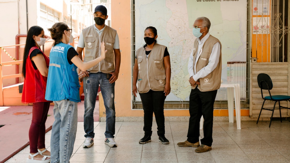 Lucetti (in red) chats with her fellow humanitarian workers at Caritas' Manaus headquarters.