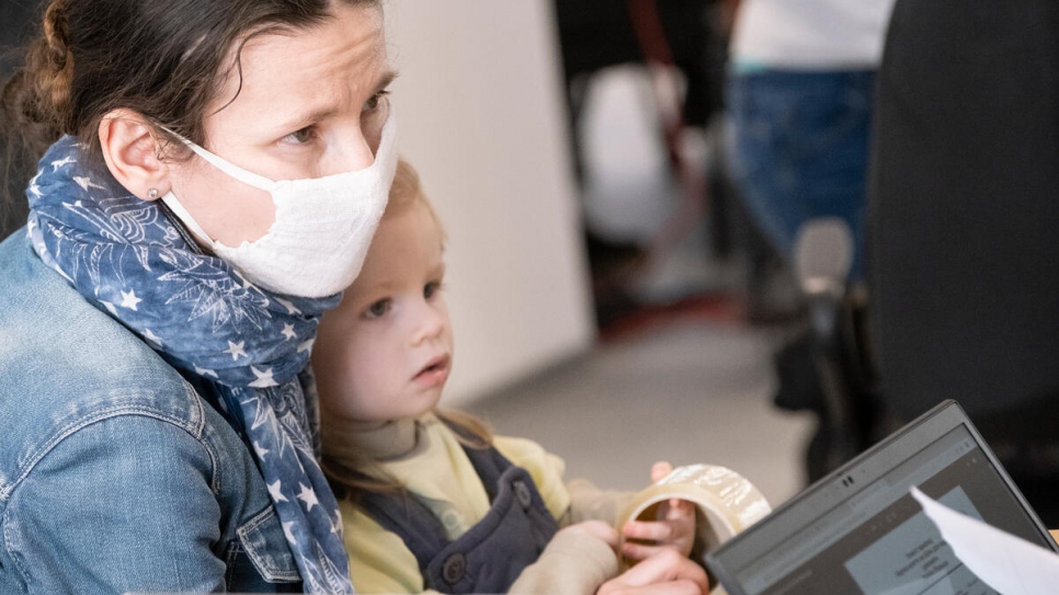 Rozalia provides her details to a staff member at UNHCR's cash enrolment centre in Warsaw. 