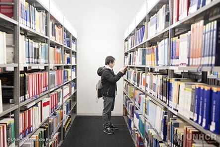 Ragazzo in università che sceglie un libro