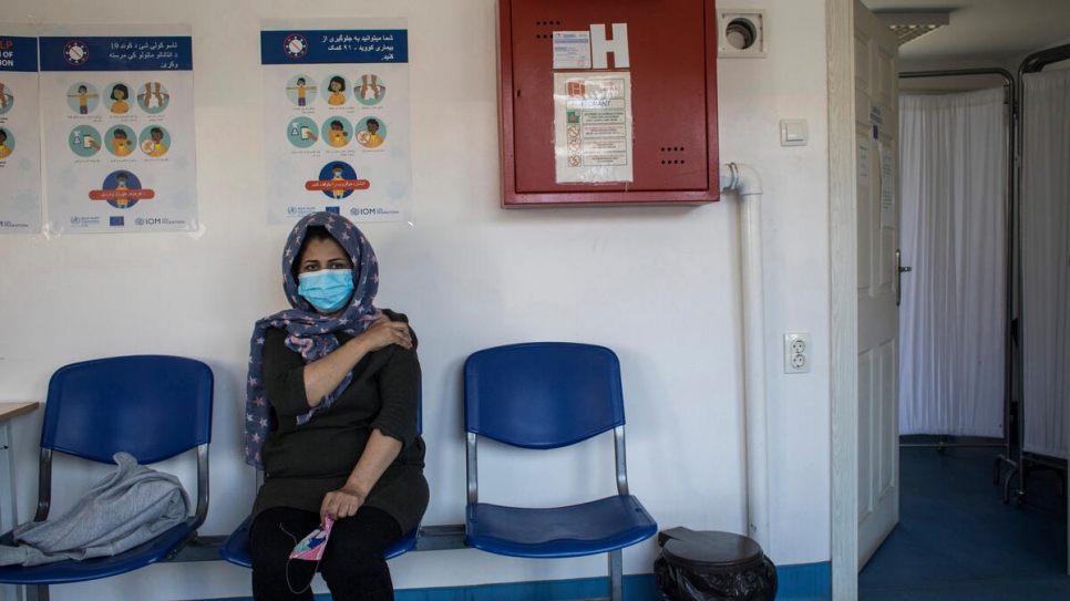 A woman at an asylum centre outside the Serbian capital rests after receiving a dose of a coronavirus vaccine. 