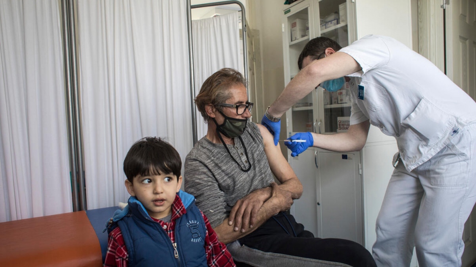 A resident of an asylum centre outside Belgrade receives a jab of coronavirus vaccine.