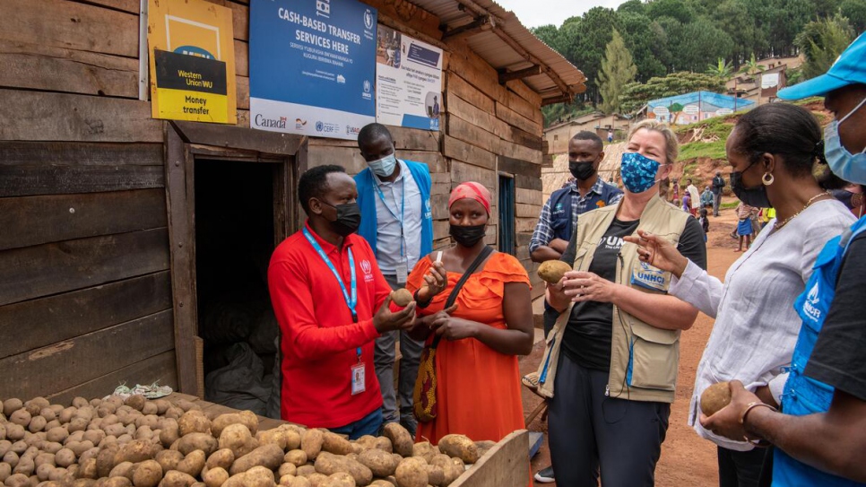 La Haut Commissaire adjointe du HCR, Kelly Clements (au centre) discute avec Olive Kanyange, une réfugiée congolaise et commerçante, dans le camp de réfugiés de Mugombwa au Rwanda.  