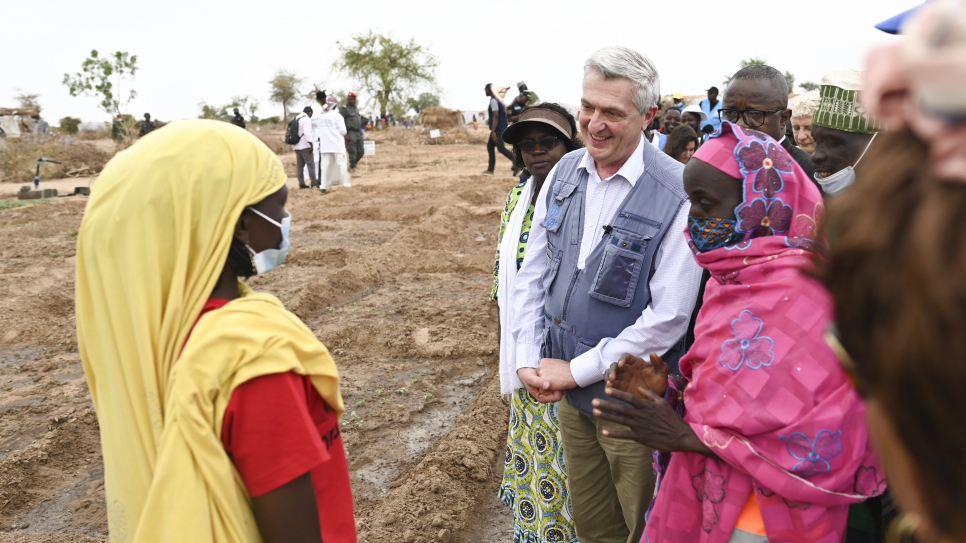 Filippo Grandi et Millicent Mutuli, Directrice du Bureau régional du HCR pour l'Afrique de l'Ouest et du Centre (au centre-gauche), discutent avec l'un des résidents du site de déplacés d'Ardjaniré. 