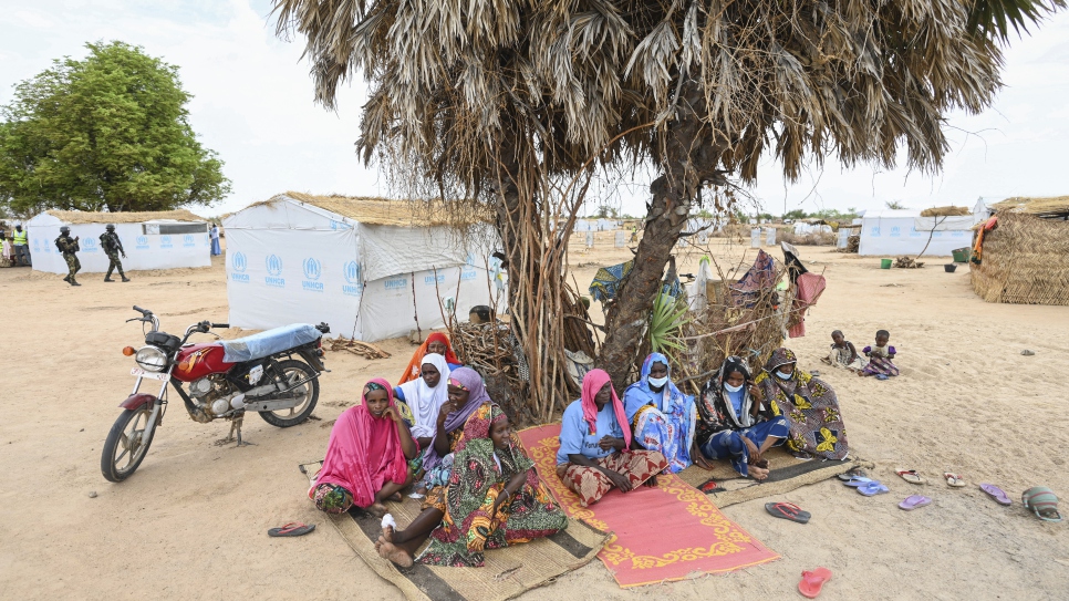 Des personnes déplacées assises à l'ombre de l'un des rares arbres restants sur le site d'Ardjaniré. 