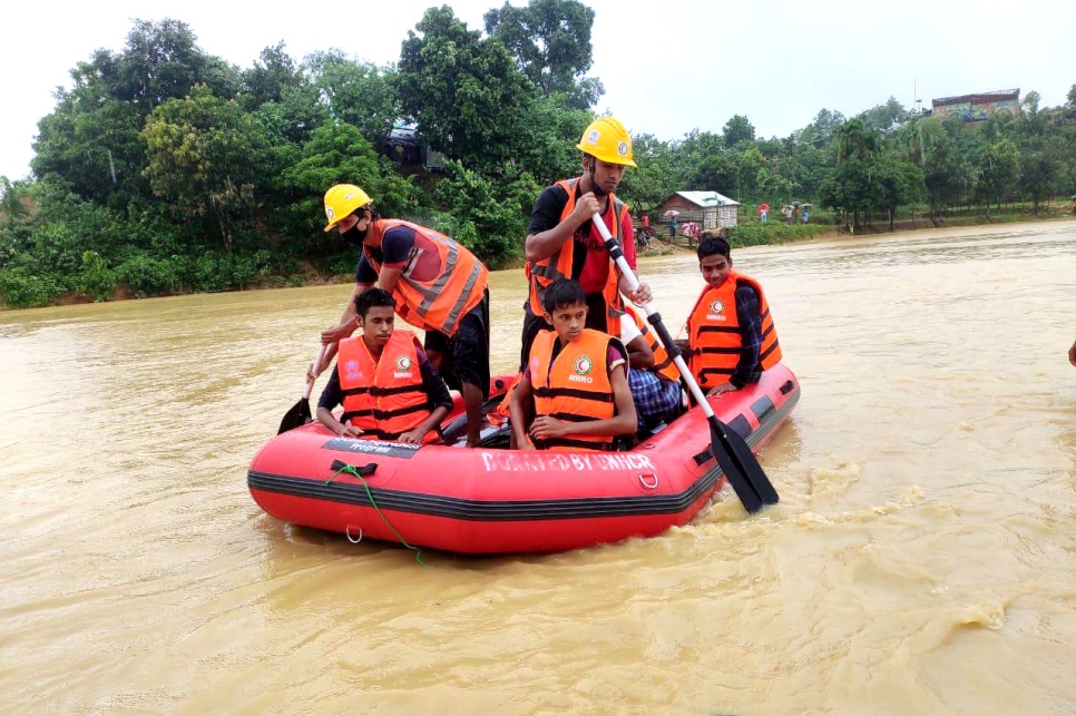 Rohingya refugees are paddled to safety at a site in Bangladesh's Cox's Bazar, after heavy monsoon rains  triggered flash floods and landslides.