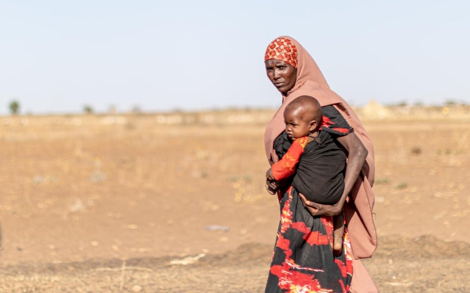 Une mère porte son enfant dans une zone aride de l'Ethiopie, dans la région Somali, où des milliers de familles ont été déplacées lors d'une récente sécheresse. 