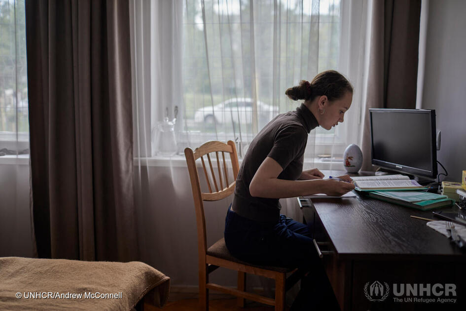 Daria studeert aan het bureau in de slaapkamer van haar familie, waar ze online lessen volgt met haar Oekraïense leerkrachten en klasgenoten.