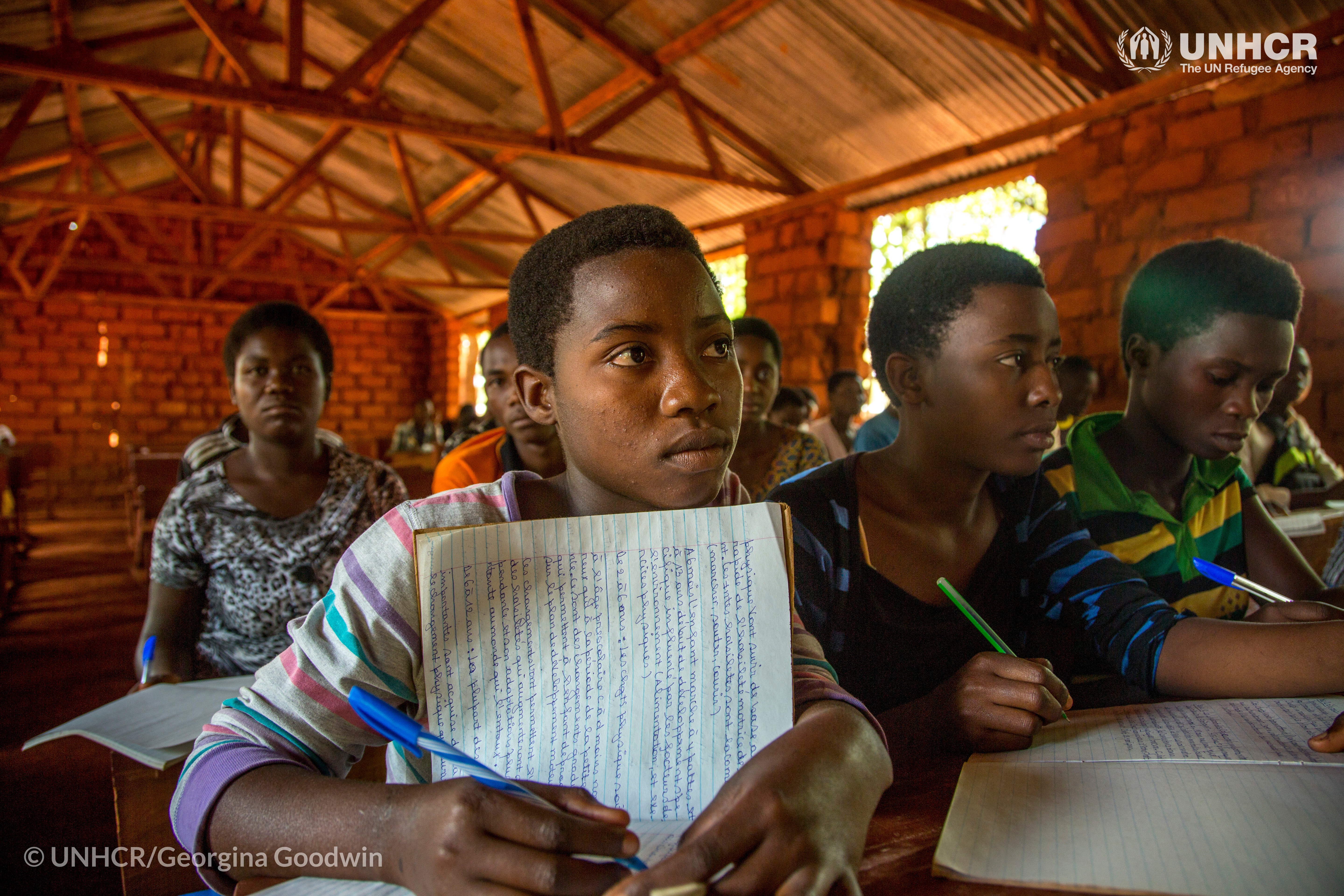 Mmane Alini, een 17-jarige Burundese leerling, neemt notities in de klas op de Hope Secondary School van het Nduta vluchtelingenkamp in Tanzania. © UNHCR/Georgina Goodwin