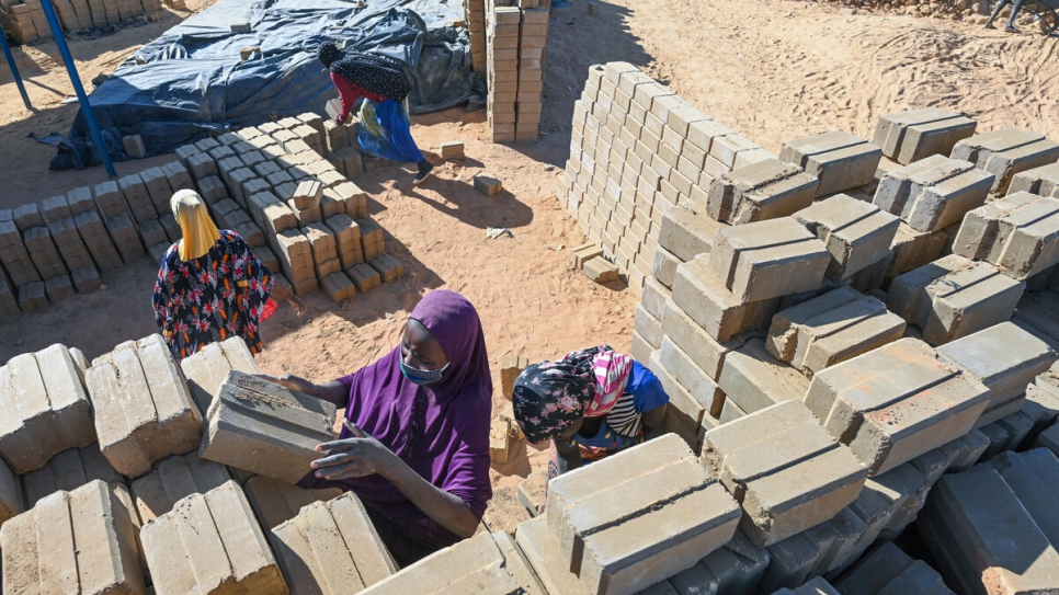 Safia Adamou, 22 ans, empile des briques fraîchement fabriquées dans la briqueterie de Ouallam, où plus d'un million de briques ont été produites et 380 nouvelles maisons construites. 