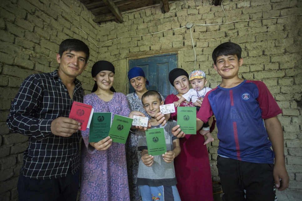 A leur domicile, les membres d'une famille anciennement apatride montrent leurs passeports récemment obtenus à Douchanbé, au Tadjikistan. 