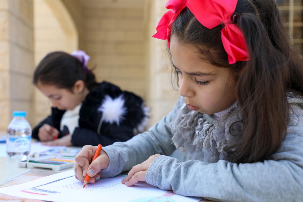 ميس، 7 أعوام، ومرح، 9 أعوام، يرسمان صوراً لسوريا في مركز مجتمعي في مأدبا، الأردن.
