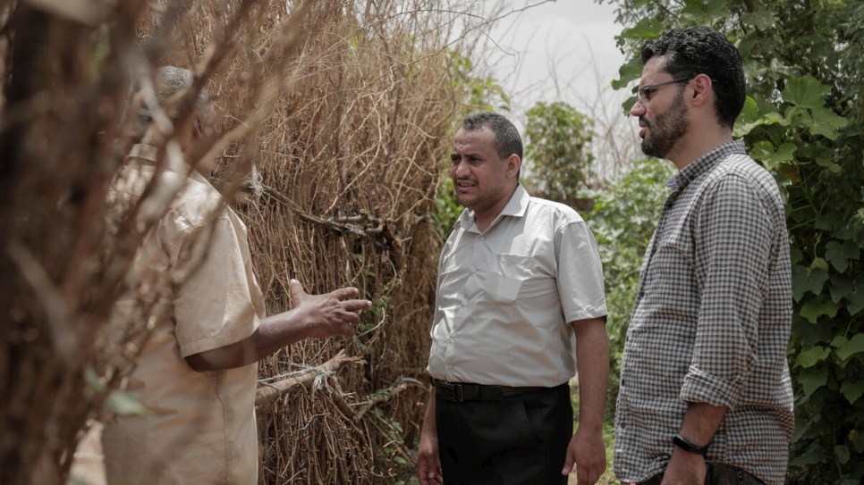 Ameen Jubran (au centre), dirigeant et co-fondateur de l'organisation caritative Jeel Albena, s'entretient avec un déplacé dans une installation près de Hodeida, au Yémen.  