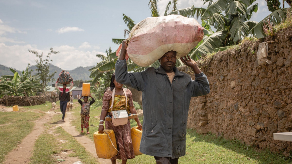 Twaza Enoch mène sa famille alors qu'ils rentrent chez eux à pied en République démocratique du Congo. 