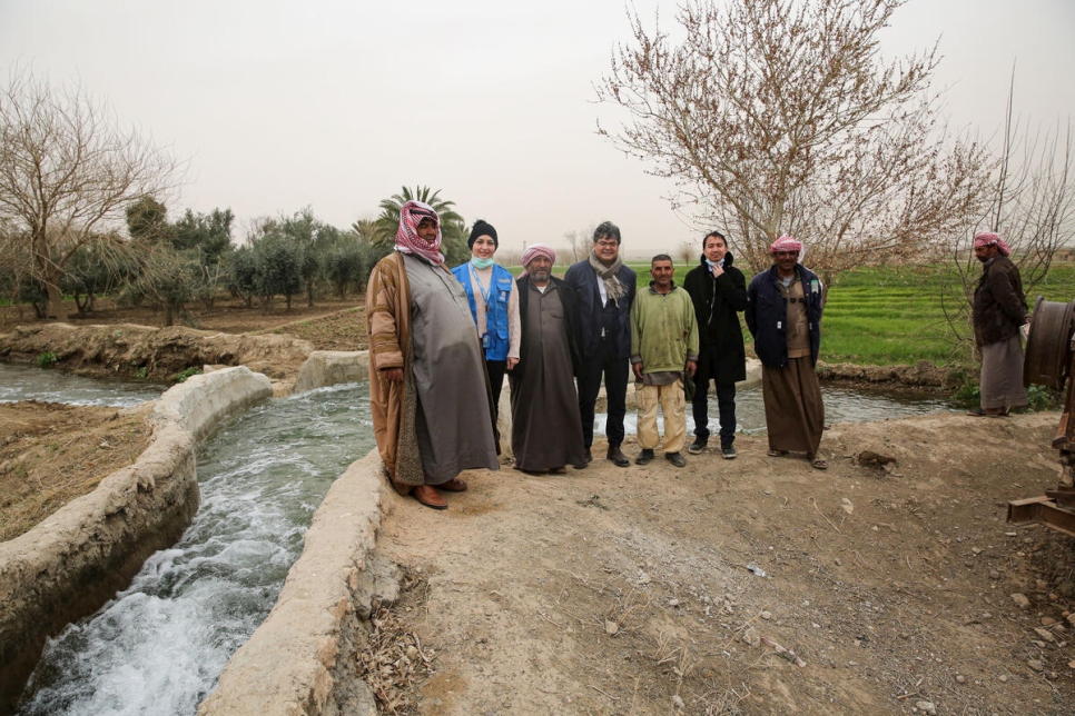 Des agriculteurs du village d'Al-Keshmah observent l'eau provenant d'une station d'irrigation réparée qui s'écoule dans des canalisations en béton vers leurs terres à Deir ez-Zor, dans l'est de la Syrie. 