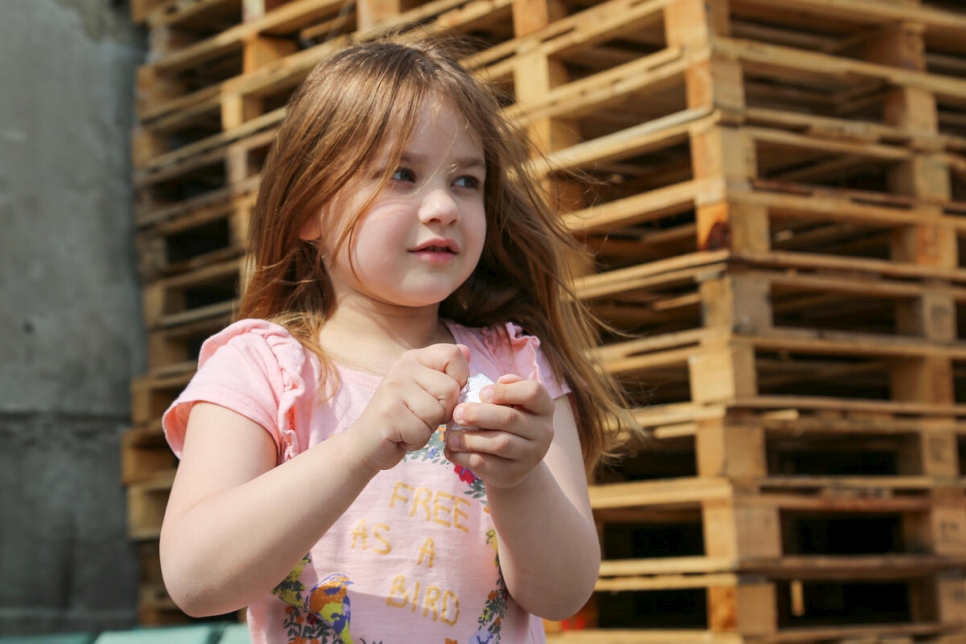 Veronika, une réfugiée ukrainienne de 6 ans, est photographiée à l'extérieur du logement de sa famille situé dans les bureaux reconvertis d'une entreprise de fabrication de palettes en Moldavie.  