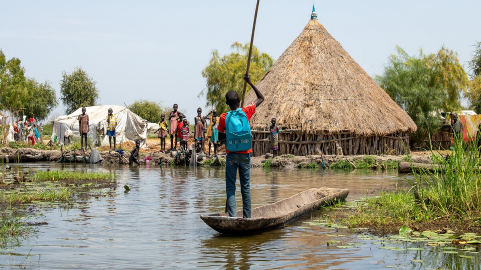 Un garçon rentre de l'école avec sa pirogue.