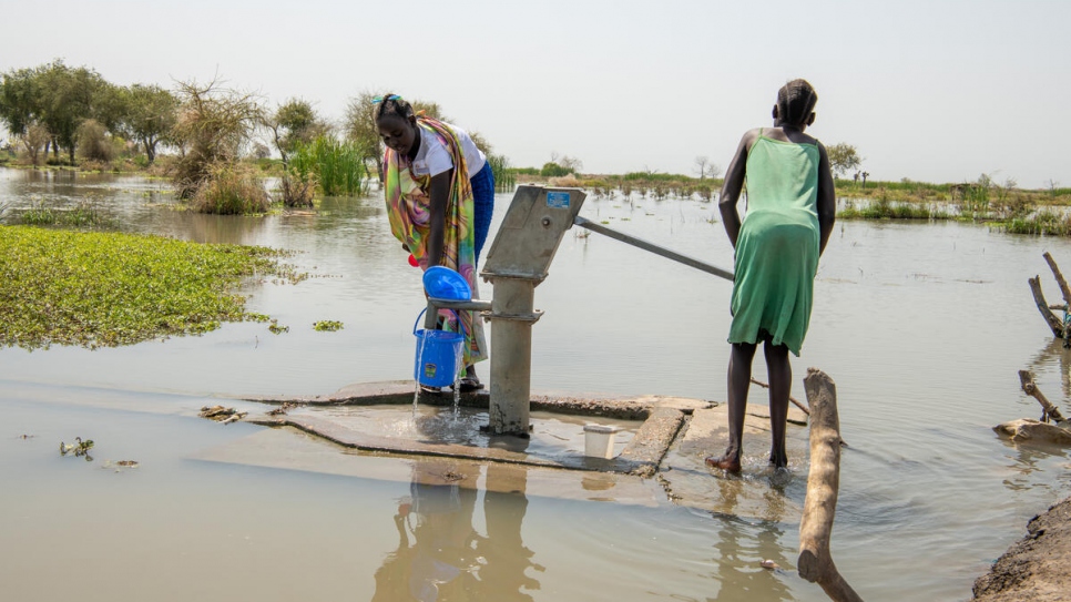 Des enfants pompent de l'eau potable d'un puits partiellement submergé à Old Fangak.